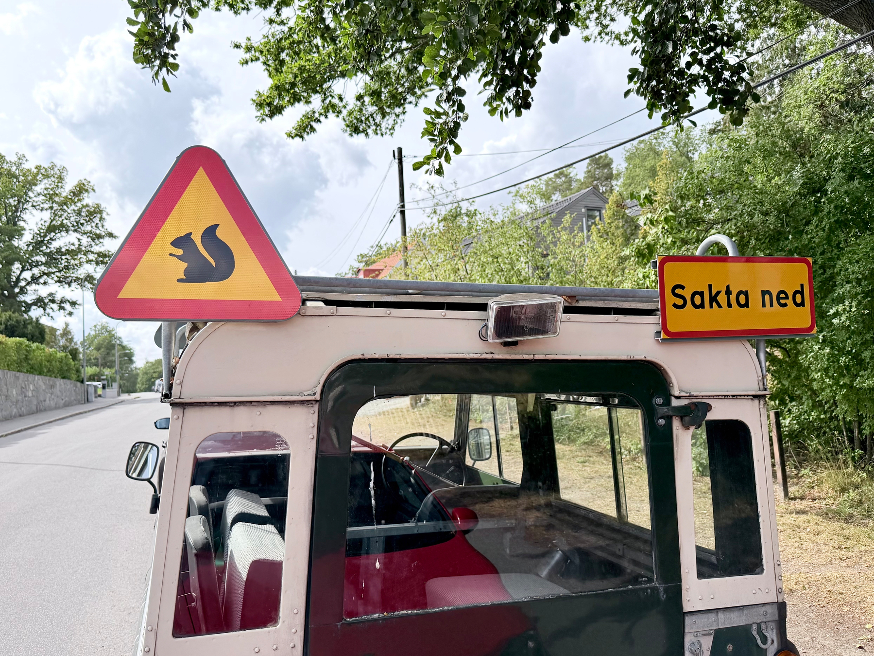 En varningsskylt för ekorrar och en skylt med texten Sakta ned är fästa på baksidan av ett fordon.